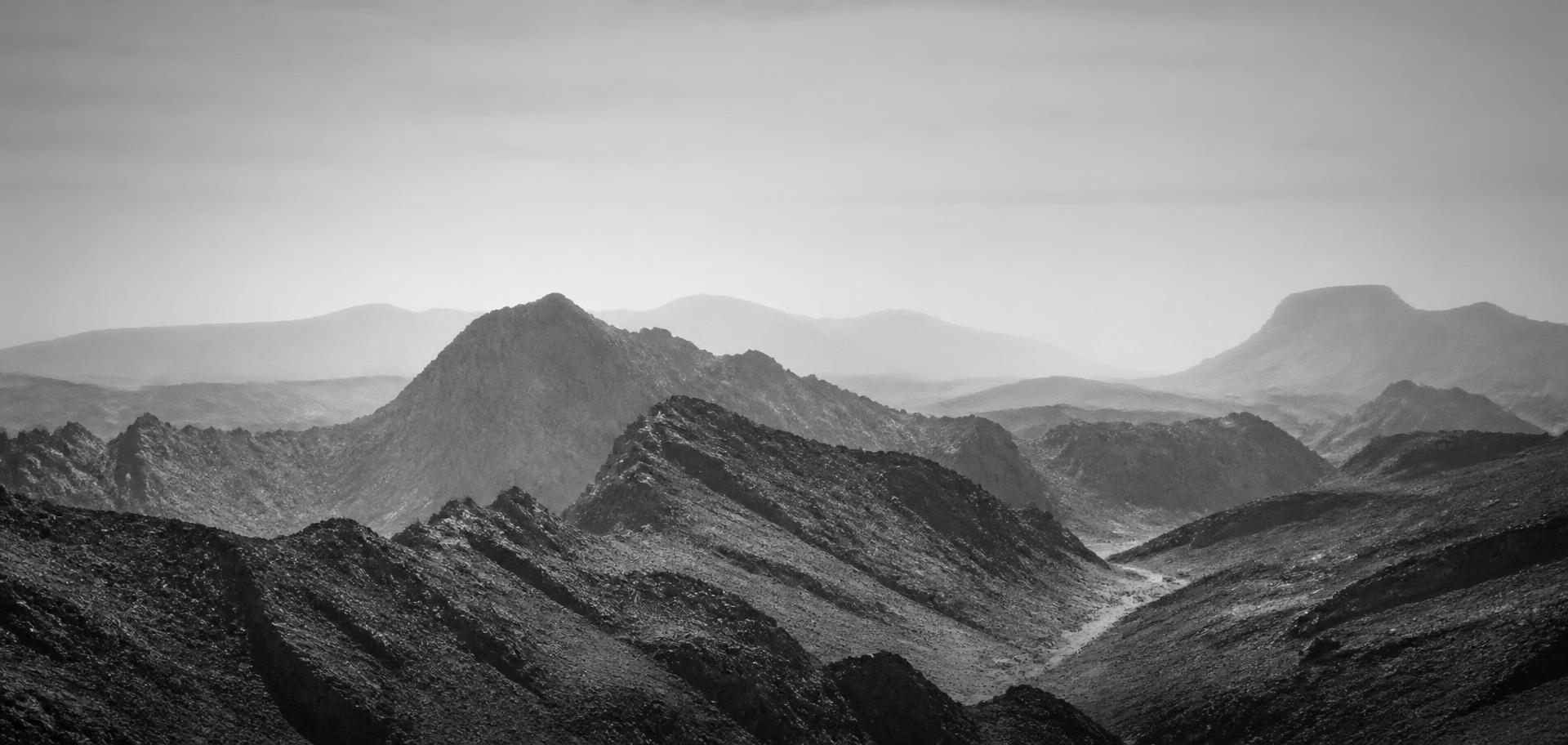 The Al Hajar mountains outside Muscat, folded rock catching low sun.